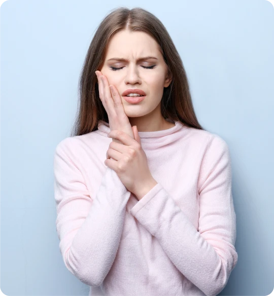 Femme portant la main à la joue, douleur dentaire avant traitement