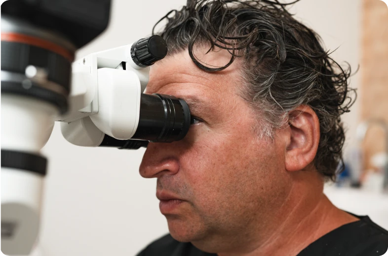 Endodontiste regardant dans un microscope opératoire lors d'un traitement de canal, Paris 16