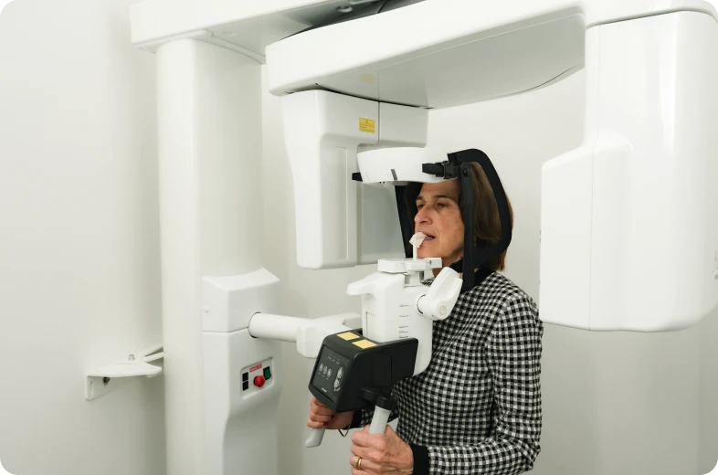 Patiente positionnée devant un appareil de radiologie 3D cone beam dans un cabinet dentaire à Paris 16