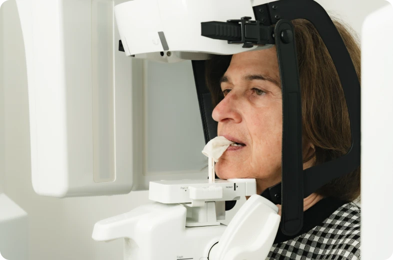 Patient positionné de profil devant un scanner cone beam pour une radiologie dentaire 3D à Paris 16